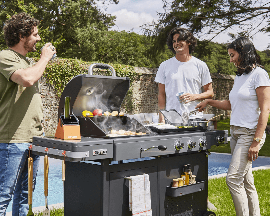 amis autour d'une plancha qui cuisinent et boivent un verre