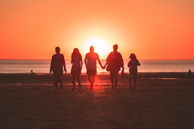 Groupe de personnes sur la plage au coucher de soleil