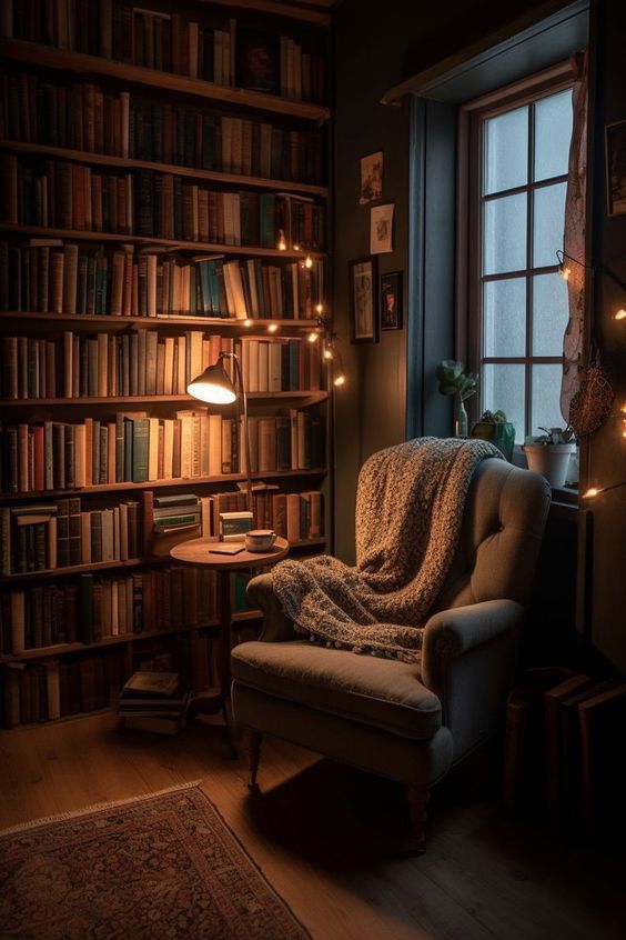 Bibliothèque tamisée avec lampe posée sur une table et grand fauteuil