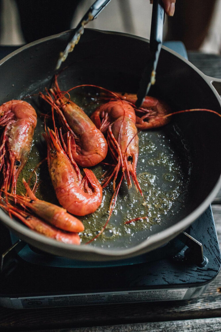 Cuisson de crevettes au beurre dans une poêle en fonte